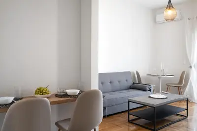a living room with a blue couch and a table at Bivium Suites by LobbySquare in Athens