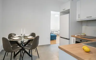 a kitchen with a table and chairs in a kitchen at Bivium Suites by LobbySquare in Athens