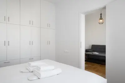 a white room with white cabinets and white towels at Bivium Suites by LobbySquare in Athens