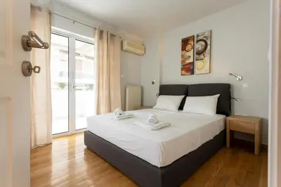 a bedroom with a large bed and a window at YestayHomes Two Bedroom Apartment Aristipou in Athens