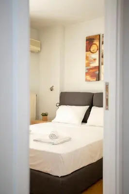 a bedroom with a large bed with white sheets at YestayHomes Two Bedroom Apartment Aristipou in Athens