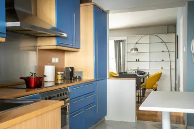 a kitchen with blue cabinets and a dining room at YestayHomes Two Bedroom Apartment Aristipou in Athens