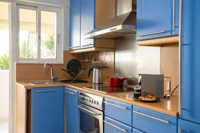 a kitchen with blue cabinets and a stove top oven at YestayHomes Two Bedroom Apartment Aristipou in Athens