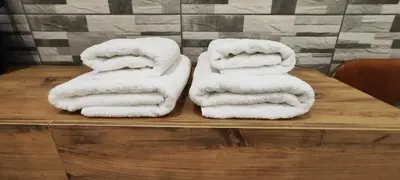 two piles of towels sitting on a wooden table at Ilisia apartment for rent in Athens