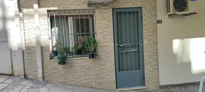 a brick building with a door and two plants in a window at Ilisia apartment for rent in Athens