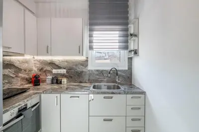 a kitchen with white cabinets and a sink at The HostMaster Timeless Elegance in Athens