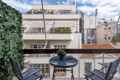 a table and chairs on a balcony with a building at The HostMaster Timeless Elegance in Athens