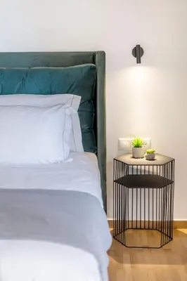 a bed with a green headboard and a side table at The HostMaster Timeless Elegance in Athens