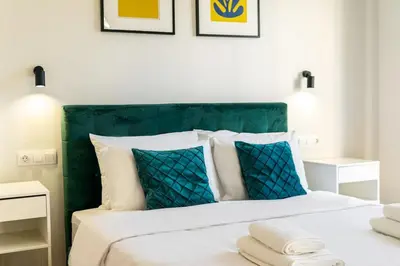 a bedroom with a bed with a green headboard and pillows at 3 Bedroom Gem at METRO in Athens