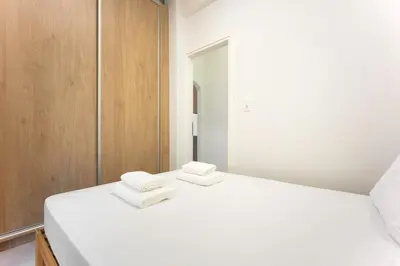 a bedroom with a white bed with two towels on it at 3 Bedroom Gem at METRO in Athens
