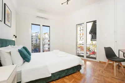 a white bedroom with a bed and a desk at 3 Bedroom Gem at METRO in Athens