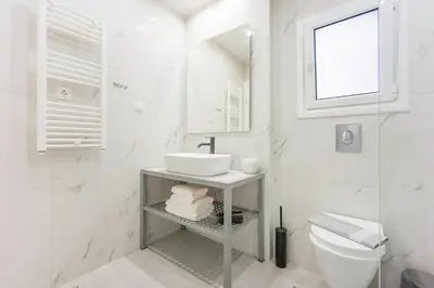 a white bathroom with a sink and a toilet at 3 Bedroom Gem at METRO in Athens