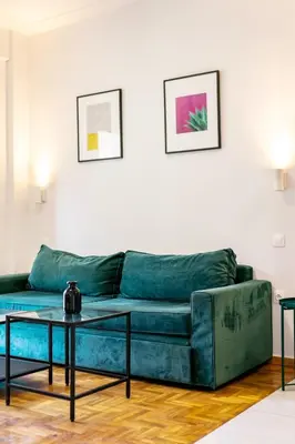 a living room with a green couch and a table at 3 Bedroom Gem at METRO in Athens