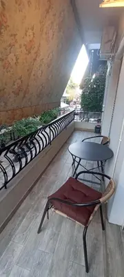 a table and a chair on a balcony with a table and chairs at Michali's Sepolia Agios Meletis Apartment in Athens