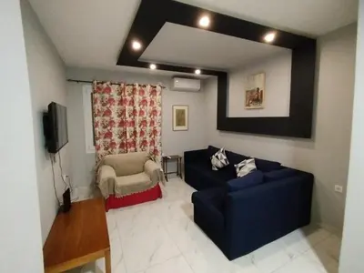a living room with a blue couch and a chair at Michali's Sepolia Agios Meletis Apartment in Athens