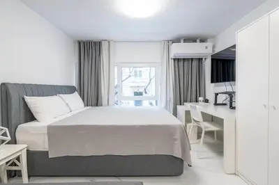 a white bedroom with a bed and a desk at Modern Gem in Central Athens in Athens