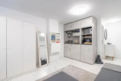 a living room with white walls and a gray cabinet at Modern Gem in Central Athens in Athens