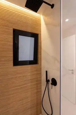 a bathroom with a television on a wall with a shower at LIV - Spacious Flat for Friends & Family in Athens