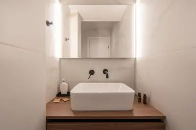 a bathroom with a white sink and a mirror at LIV - Spacious Flat for Friends & Family in Athens
