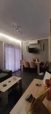 a living room with couches and tables in a room at Spiros cozy place in Saronida