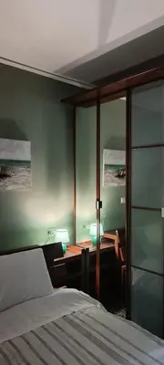 a bedroom with a bed and a desk with a lamp at Spiros cozy place in Saronida