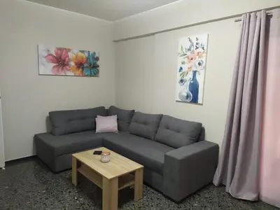 a living room with a couch and a table at Spiros cozy place in Saronida