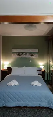 a bedroom with a large bed with two towels on it at Spiros cozy place in Saronida