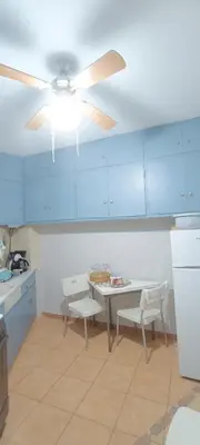 a kitchen with a table and a ceiling fan at Spiros cozy place in Saronida