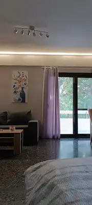 a bedroom with a bed and a purple curtain at Spiros cozy place in Saronida