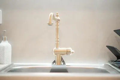 a kitchen sink with a gold faucet at Radiant Apt near Lycabettus in Athens