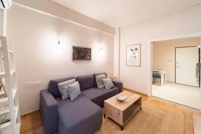 a living room with a blue couch and a table at Radiant Apt near Lycabettus in Athens