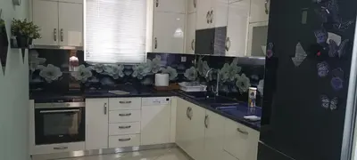 a kitchen with white cabinets and black counter tops at Thimarakia Maniakiou Apartment in Athens