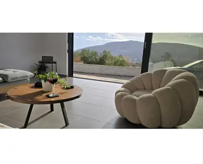 a living room with a table and a chair at Aquarius Luxury Suites in Ólimbos