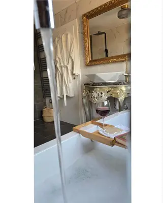 a bathroom with a bath tub with a glass of wine at Aquarius Luxury Suites in Ólimbos