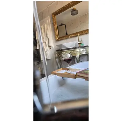 a glass of wine sitting on a table in a bath tub at Aquarius Luxury Suites in Ólimbos