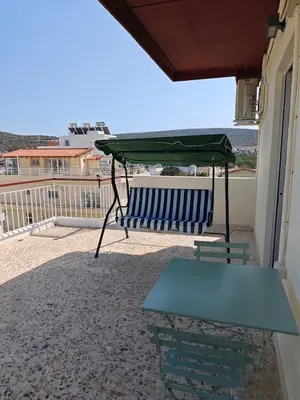 a table and a green canopy on a balcony at Aspa and Alex penthouse retreat in Koropíon