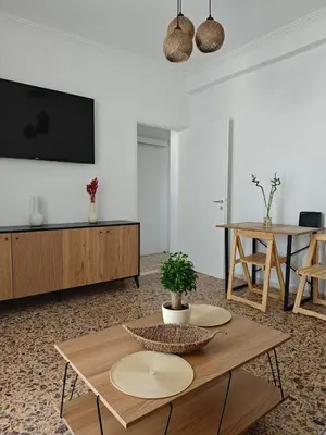 a living room with a table and a tv at Aspa and Alex penthouse retreat in Koropíon