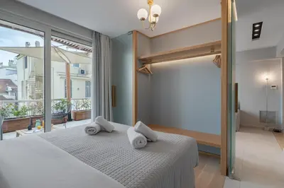 a bedroom with a white bed with towels on it at Aphrodite - Luxenia Suites in Athens