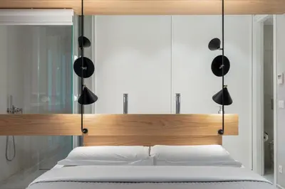 a bedroom with a bed with a wooden headboard at Aphrodite - Luxenia Suites in Athens