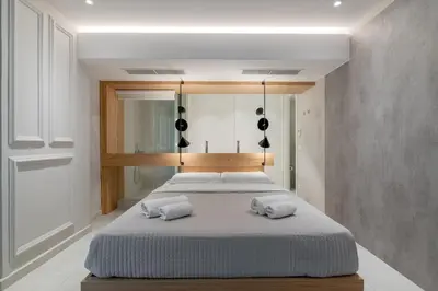 a bedroom with two beds with white sheets at Aphrodite - Luxenia Suites in Athens
