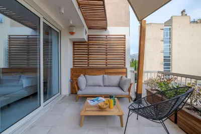 a patio with a couch and a table on a balcony at Aphrodite - Luxenia Suites in Athens