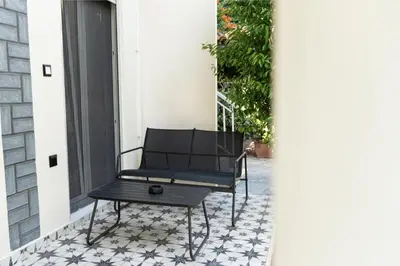 a black chair sitting on the porch of a house at Annasa Apartments in Athens
