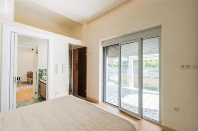 a bedroom with a bed and a large window at Annasa Apartments in Athens