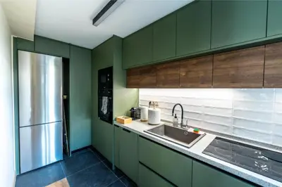 a kitchen with green cabinets and a stainless steel refrigerator at Annasa Apartments in Athens
