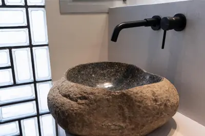 a large stone bowl sitting on a table next to a wall at Annasa Apartments in Athens