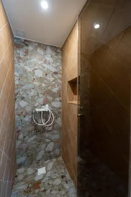 a bathroom with a shower with a stone wall at Annasa Apartments in Athens