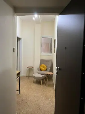 a room with a couch and a chair with a yellow pillow at Acropolis Urban sidewalk view in Athens