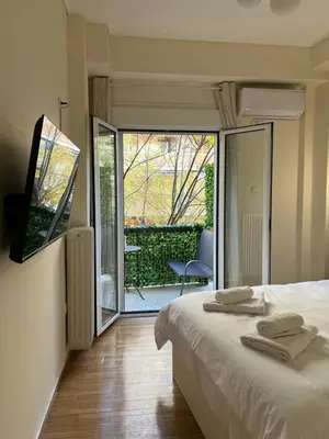 a bedroom with a bed and a view of a balcony at Acropolis Urban sidewalk view in Athens