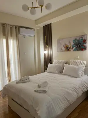 a bedroom with a white bed with two towels on it at Acropolis Urban sidewalk view in Athens