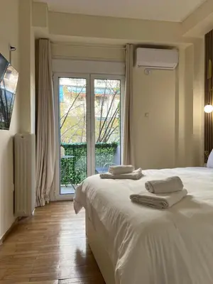 a bedroom with a white bed and a large window at Acropolis Urban sidewalk view in Athens